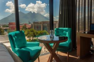 ein Zimmer mit zwei Stühlen und einem Tisch mit Aussicht in der Unterkunft Hotel Kavia Monterrey in Monterrey