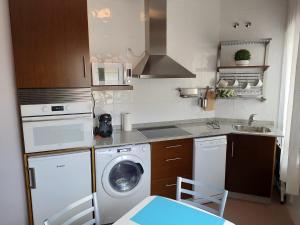 a kitchen with a washing machine and a washer at Apartamento Playa de Coira II in Portosin +5 photos
