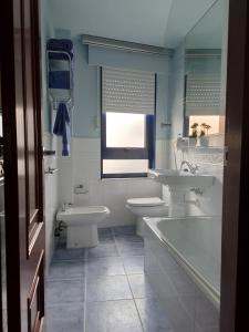 y baño con 2 lavabos, bañera y aseo. en Apartamento Playa de Coira II, en Portosín