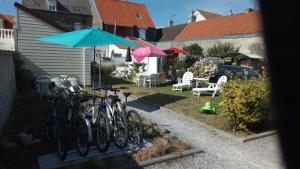 - un groupe de vélos garés dans une cour avec parasols dans l'établissement Orchidée, à Berck-sur-Mer