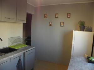 a kitchen with a sink and a white refrigerator at Apartament „STARY RYNEK” Słupsk in Słupsk