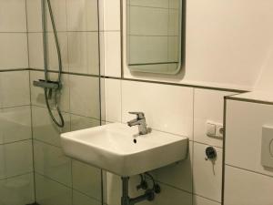 ein Bad mit einem Waschbecken und einem Spiegel in der Unterkunft Aurora Schaar 3 in Wilhelmshaven