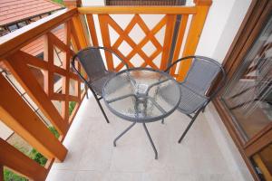 een tafel en 2 stoelen op een balkon bij Zlatiborska Vila 1 Lux in Zlatibor