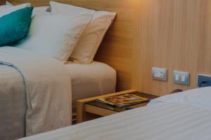 um quarto de hotel com duas camas e uma mesa com um livro em Hotel Kavia Monterrey em Monterrey