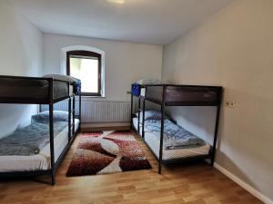 a room with three bunk beds and a rug at Klein aber fein! in Emskirchen