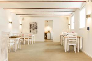 a dining room with white tables and white chairs at Hof Hallenberg in Hallenberg