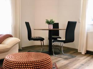 einen Tisch und Stühle im Wohnzimmer mit einem Tisch in der Unterkunft Aurora Schaar 3 in Wilhelmshaven