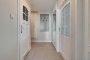 a hallway with white doors and a tile floor at Merida Apartament in Sopot