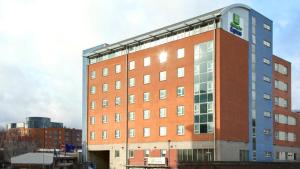 a large red brick building in a city at Holiday Inn Express London Limehouse, an IHG Hotel in London
