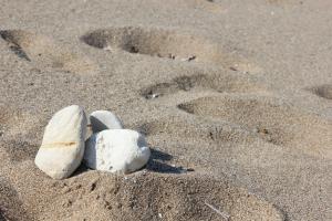 a pair of rocks in the sand on a beach at Galini in Agia Irini Milos