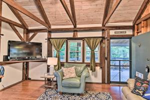 a living room with wooden ceilings and a tv and a chair at Newland Cottage 3 Miles to Grandfather Mtn Park! in Newland