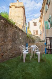 un grupo de sillas y una mesa en el césped en Hostel Adriatic Piran en Piran
