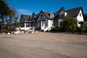 a large house with a gravel driveway in front of it at Glen Clova Hotel & Luxury Lodges in Millton of Clova