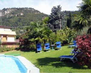 een groep blauwe stoelen in een tuin naast een zwembad bij Hotel St. Antony in Bardolino