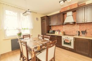 a kitchen with a table and chairs in a room at Apartament Kapitański in Hel