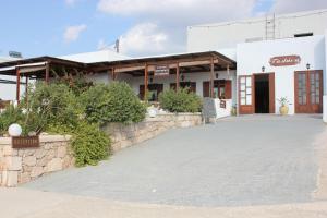 a building with a stone wall next to a street at Galini in Agia Irini Milos