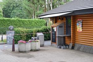 a wooden cabin with flowers in front of it at Chalet nr 30 in Putten in Putten