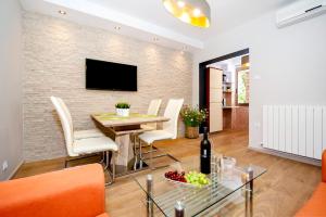ein Wohnzimmer mit einem Tisch und einem TV an einer Backsteinwand in der Unterkunft Apartments Modrušan in Rovinj