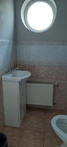 a bathroom with a sink and a round window at Jūras Vilks in Ventspils