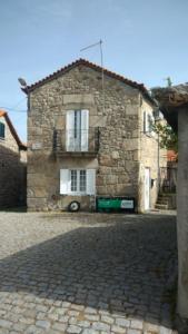 una casa in pietra con balcone su una strada di mattoni di Governo's House a Melo