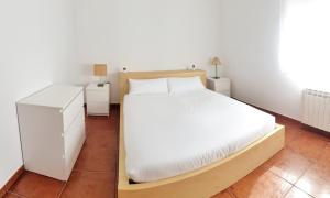 1 dormitorio con 1 cama blanca y 2 mesitas de noche en Apartamento Garro by SanSe Holidays, en San Sebastián
