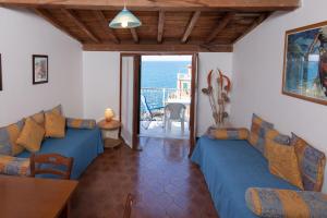 una sala de estar con 2 sofás azules y una mesa. en L'ORIZZONTE, en Riomaggiore