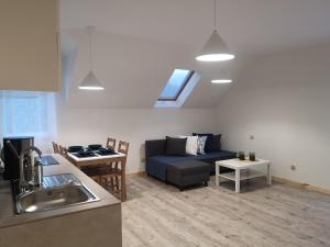 salon z niebieską kanapą i kuchnią w obiekcie ApartDębki w mieście Odargowo