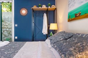 1 dormitorio con cama y pared azul en Ammos Beach House en Glyfada