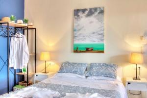 um quarto com uma cama e um quadro na parede em Ammos Beach House em Glyfada