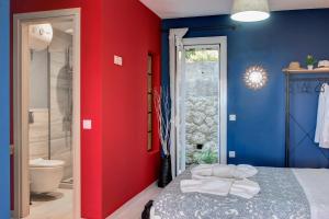 a red and blue bedroom with a bed and a shower at Ammos Beach House in Glyfada