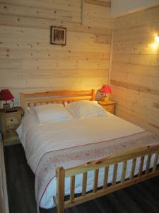 a bedroom with a bed in a log cabin at Hôtel Chalet Le Caribou in Les Saisies