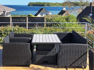 a picnic table and chairs on a deck with the ocean at 6 person holiday home in Hejls in Hejls