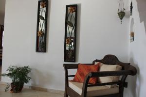 a chair sitting in a room with three mirrors at Galini in Agia Irini Milos