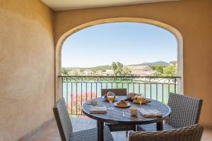 a table and chairs on a balcony with a view at Village Pierre & Vacances Pont Royal en Provence in Mallemort