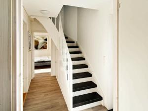 eine Treppe in einem Haus mit weißen Wänden und Holzböden in der Unterkunft Two-Bedroom Holiday home in Wendtorf 19 in Wendtorf