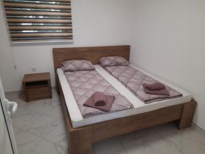 a bed with two pillows on it in a room at Apartman Dzenis in Bihać