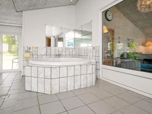 a large bathroom with a tub and a mirror at 10 person holiday home in Hals in Hou