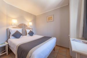 a hotel room with a large bed with two pillows at Village Pierre & Vacances Pont Royal en Provence in Mallemort