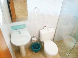 y baño con aseo, lavabo y ducha. en HF Minas Hotel, en Vespasiano