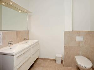 y baño con lavabo, aseo y espejo. en Two-Bedroom Holiday home in Wendtorf 23, en Wendtorf