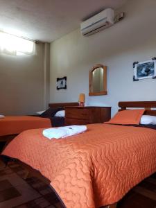 a bedroom with two beds and a mirror at Hostal Cattleya in Puerto Baquerizo Moreno