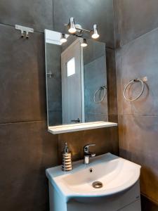 a bathroom with a sink and a mirror at Αλός αήρ suites in Kithnos
