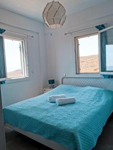 a bedroom with a bed with two towels on it at Αλός αήρ suites in Kithnos