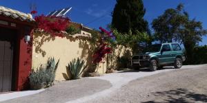 un camión verde estacionado junto a un edificio con flores en Casa Rural Cortijos San Jose en Iznájar
