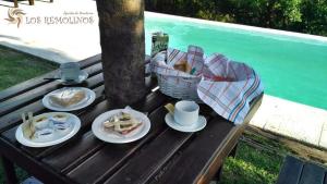 a picnic table with plates of food and a basket of food at Los Remolinos in Merlo