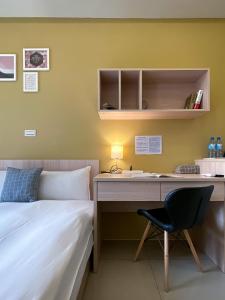 
a bedroom with a bed and a desk at Adagio Hostel in Taichung
