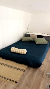 un lit dans une chambre avec une couverture bleue dans l'établissement Le Grand Mole - 2 à 8 voyageurs, à Sète