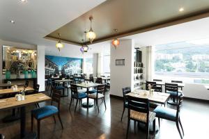 ボゴタにあるHotel bh Usaquénのテーブルと椅子と窓のあるダイニングルーム