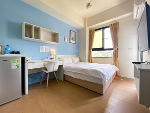 um pequeno quarto com uma cama e uma secretária em Adagio Hostel em Taichung