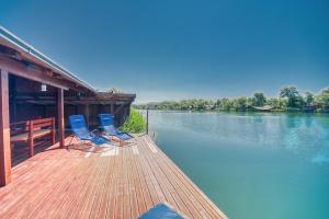 2 chaises bleues assises sur un quai à côté d'une rivière dans l'établissement Rudovic River House, à Ulcinj